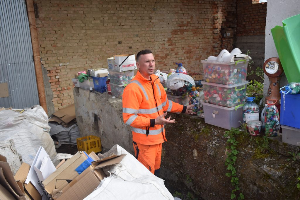 Viktor a hulladékgyűjtő udvaron mutatja az iskolákban összegyűjtött kupakokat